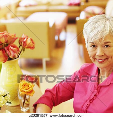 Portrait of a senior woman sitting and smiling View Large Photo Image Stock Photo - Portrait of a senior woman sitting and smiling. Fotosearch