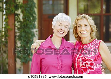 Stock Photography - Portrait of two women standing together and smiling. Fotosearch