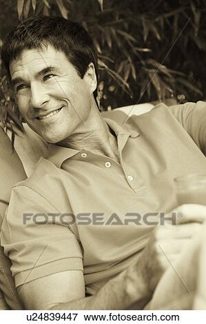Close-up of a mature man holding a glass of juice View Large Photo Image Stock Photo - Close-up of a mature man holding a glass of juice. Fotosearch