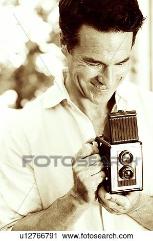 Close-up of a mature man operating a camera View Large Photo Image Stock Image - Close-up of a mature man operating a camera. Fotosearch