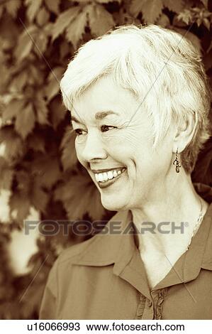 Stock Image - Close-up of a senior woman smiling and looking away. Fotosearch