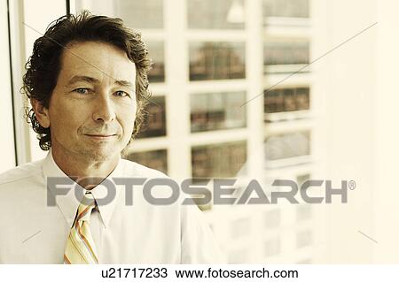 Stock Image - Portrait of a businessman smirking. Fotosearch