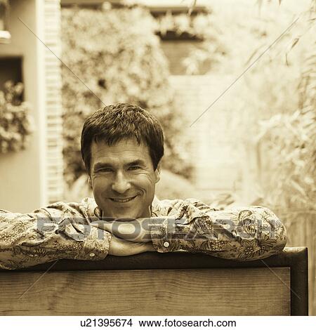Picture - Portrait of a mature man leaning on a gate. Fotosearch