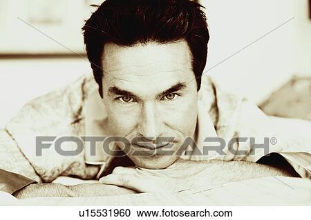Stock Image - Portrait of a mature man lying on the bed. Fotosearch