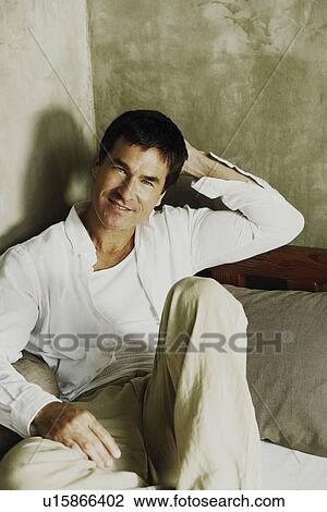 Portrait of a mature man reclining on the bed View Large Photo Image Stock Image - Portrait of a mature man reclining on the bed. Fotosearch