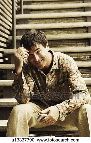 Portrait of a mature man sitting on staircase and holding a personal data assistant View Large Photo Image Stock Image - Portrait of a mature man sitting on staircase and holding a personal data assistant. Fotosearch