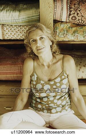 Picture - Portrait of a mature woman sitting and smiling. Fotosearch
