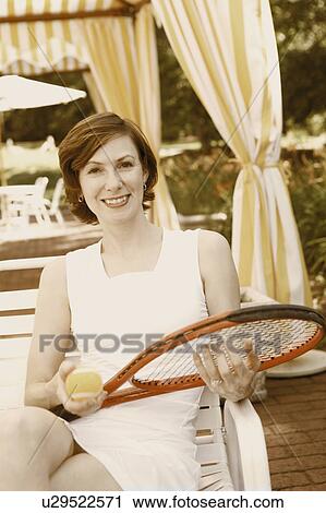 Portrait of a mid adult woman holding a tennis ball and a tennis racket View Large Photo Image Stock Image - Portrait of a mid adult woman holding a tennis ball and a tennis racket. Fotosearch