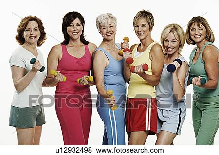 Stock Photo - Portrait of a group of mature women holding dumbbells and smiling. Fotosearch