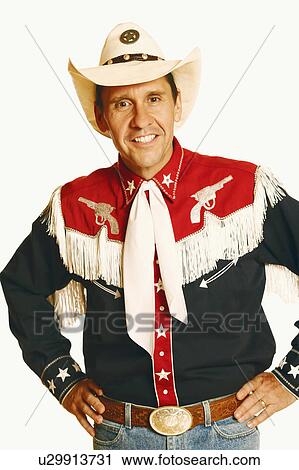 Stock Image - Portrait of a mature man standing with arms akimbo and smiling. Fotosearch