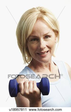 Portrait of a mature woman exercising with a dumbbell View Large Photo Image Stock Image - Portrait of a mature woman exercising with a dumbbell. Fotosearch