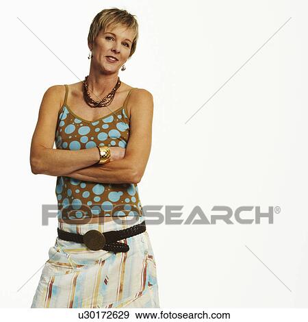 Stock Photo - Portrait of a mature woman standing with her arms crossed. Fotosearch