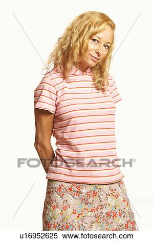 Portrait of a mature woman standing with her hands behind her back View Large Photo Image Stock Photography - Portrait of a mature woman standing with her hands behind her back. Fotosearch