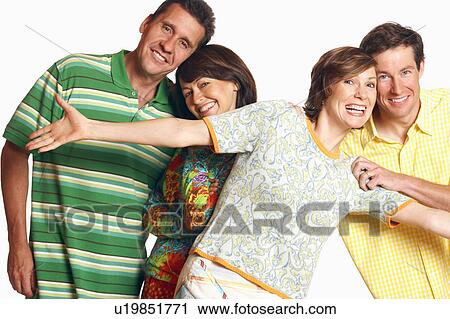 Stock Image - Portrait of a mid adult couple and a mature couple posing and smiling. Fotosearch