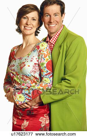 Stock Photo - Portrait of a mid adult man embracing a mid adult woman and smiling. Fotosearch