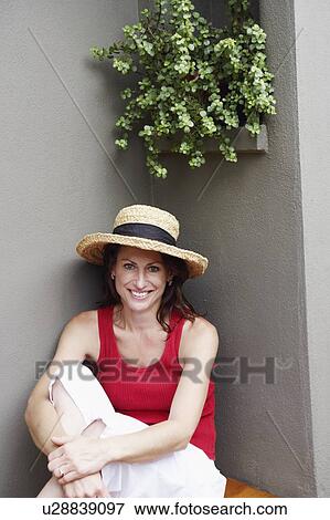 Portrait of a mature woman wearing a hat and smiling View Large Photo Image Stock Photo - Portrait of a mature woman wearing a hat and smiling. Fotosearch