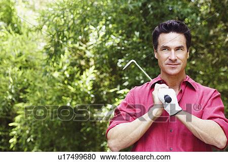 Close-up of a mature man holding a golf club View Large Photo Image Stock Image - Close-up of a mature man holding a golf club. Fotosearch