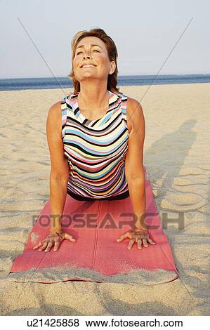 Mature woman exercising on the beach View Large Photo Image Stock Photo - Mature woman exercising on the beach. Fotosearch