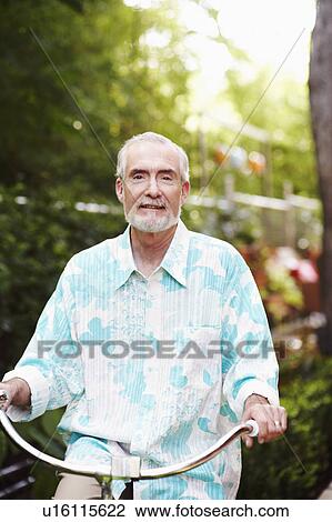 Stock Image - Portrait of a mature man riding a bicycle. Fotosearch