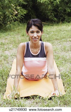Stock Image - Portrait of a mature woman doing yoga on the lawn. Fotosearch