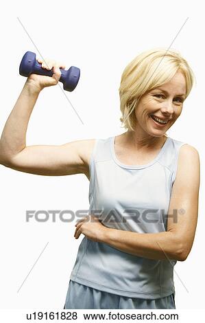 Portrait of a mature woman exercising with a dumbbell View Large Photo Image Stock Photo - Portrait of a mature woman exercising with a dumbbell. Fotosearch