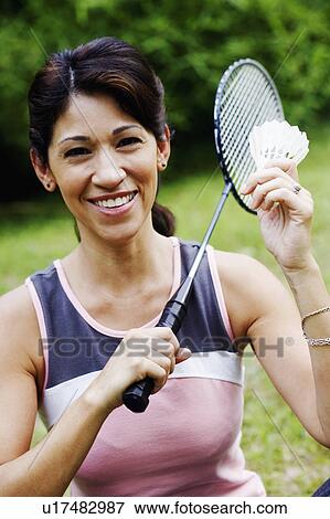 Stock Photo - Portrait of a mature woman holding a badminton racket and a shuttlecock. Fotosearch