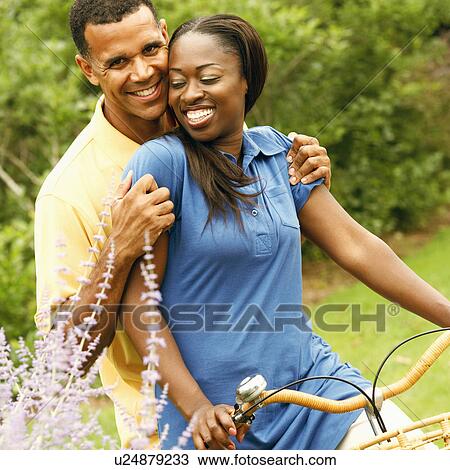 Stock Image - Portrait of a mid adult woman and a mature man cycling. Fotosearch