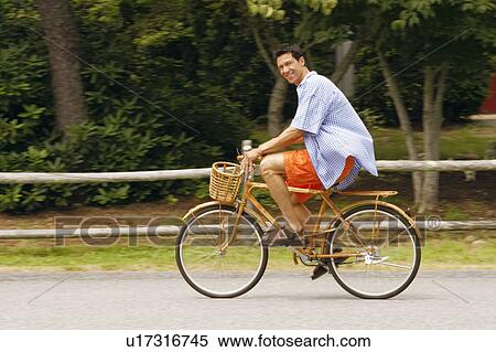 Stock Photography - Side profile of a mature man cycling. Fotosearch