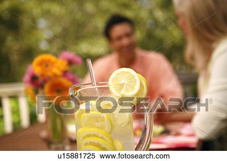 Close-up of a jug of lemon juice with two people sitting in the background View Large Photo Image Stock Photography - Close-up of a jug of lemon juice with two people sitting in the background. Fotosearch