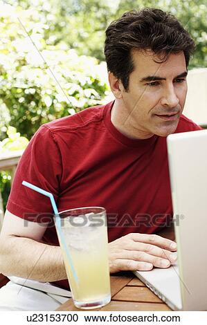 Stock Image - Close-up of a mature man using a laptop. Fotosearch