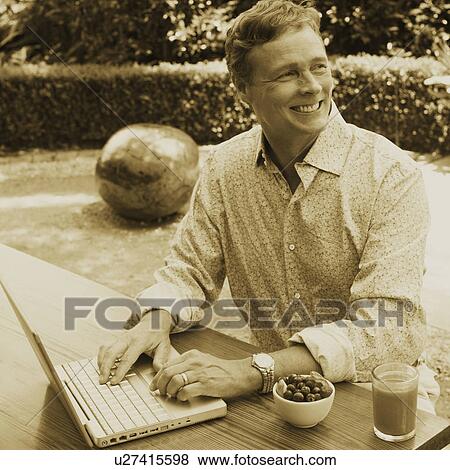 Stock Photo - Close-up of a mature man working on a laptop. Fotosearch