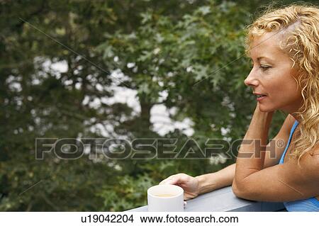 Close-up of a mature woman holding a cup of tea View Large Photo Image Picture - Close-up of a mature woman holding a cup of tea. Fotosearch