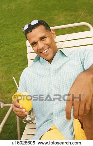 High angle view of a mature man holding a glass of juice View Large Photo Image Stock Photography - High angle view of a mature man holding a glass of juice. Fotosearch
