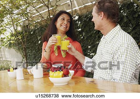 Mature couple toasting glasses of orange juice View Large Photo Image Stock Photo - Mature couple toasting glasses of orange juice. Fotosearch