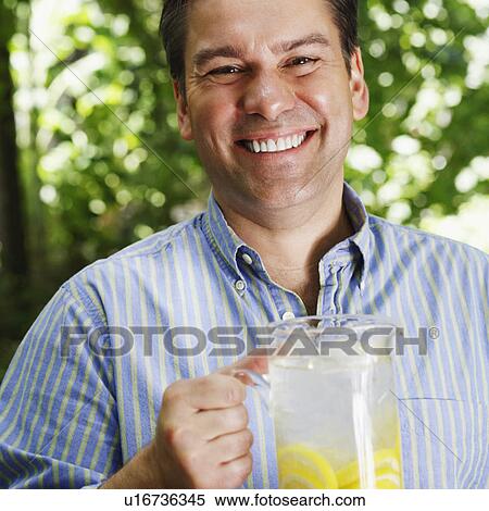 Stock Photography - Portrait of a mature man holding a pitcher of lemonade. Fotosearch