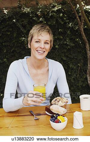 Portrait of a mature woman holding a glass of orange juice View Large Photo Image Stock Image - Portrait of a mature woman holding a glass of orange juice. Fotosearch