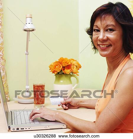 Portrait of a mature woman shopping online with a credit card View Large Photo Image Stock Photo - Portrait of a mature woman shopping online with a credit card. Fotosearch