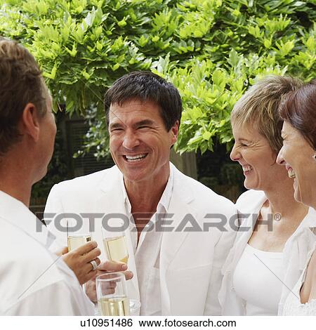 Stock Photograph - Two mature couples celebrating with champagne. Fotosearch