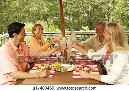 Two mature couples toasting glasses of lemon juice View Large Photo Image Stock Photo - Two mature couples toasting glasses of lemon juice. Fotosearch
