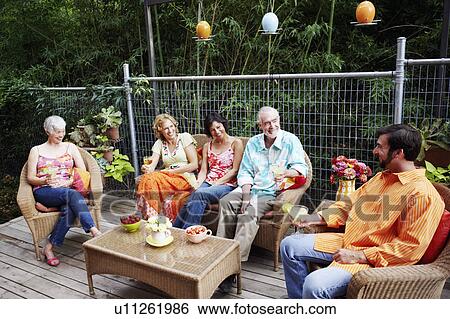 Stock Photograph - Five people sitting together and smiling. Fotosearch