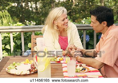 Stock Photography - Mature couple sitting at the table and looking at each other. Fotosearch