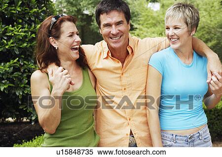 Stock Photography - Mature man and two mature women standing together and smiling. Fotosearch