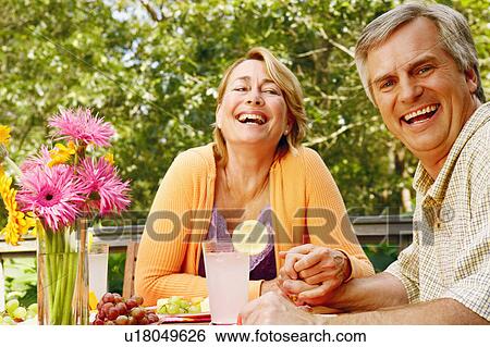 Stock Photograph - Portrait of a mature couple holding hands and smiling. Fotosearch