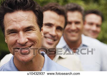 Portrait of a mature man smiling with his friends in the background View Large Photo Image Stock Photo - Portrait of a mature man smiling with his friends in the background. Fotosearch