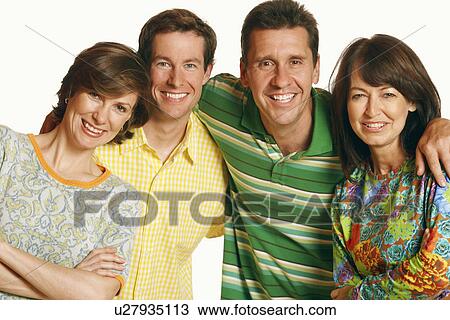 Stock Image - Portrait of a mid adult couple and a mature couple posing and smiling. Fotosearch