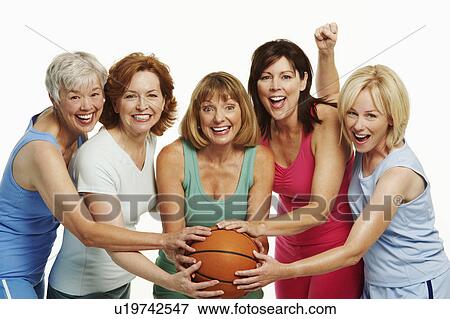 Stock Photo - Portrait of five mature women holding a basketball and smiling. Fotosearch