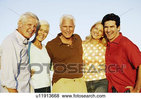 Portrait of three mature men and two mature women standing together and smiling View Large Photo Image Stock Photo - Portrait of three mature men and two mature women standing together and smiling. Fotosearch