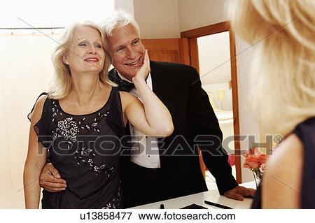 Stock Photo - Reflection of a mature woman admiring a mature man in a mirror. Fotosearch