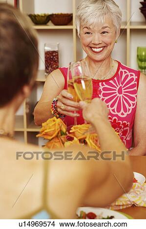 Picture - Two women toasting with champagne flutes. Fotosearch