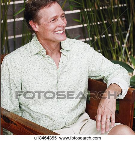 Close-up of a mature man sitting in an armchair and smiling View Large Photo Image Stock Photography - Close-up of a mature man sitting in an armchair and smiling. Fotosearch